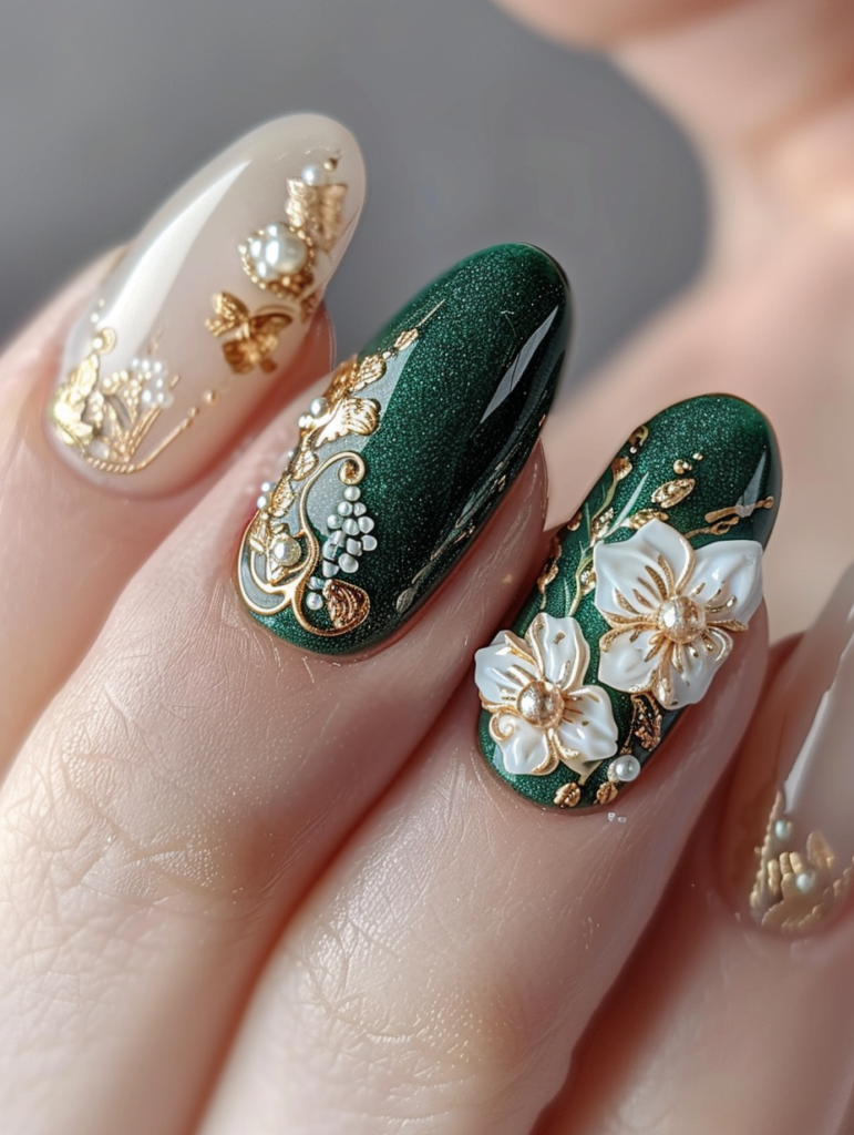 Macro close-up of a single emerald green nail with vintage Victorian floral design, white and gold flower motif, fine gold leaf swirls, pearl center, and sparkling metallic gold details