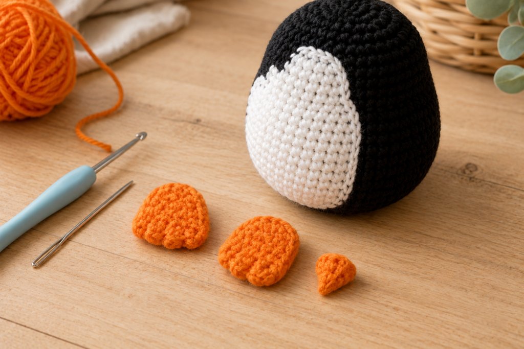 Orange crochet penguin feet and beak pieces