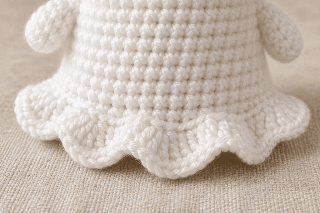 Close-up of the white crochet ghost's decorative wavy scalloped hem worked into the reserved front loops.